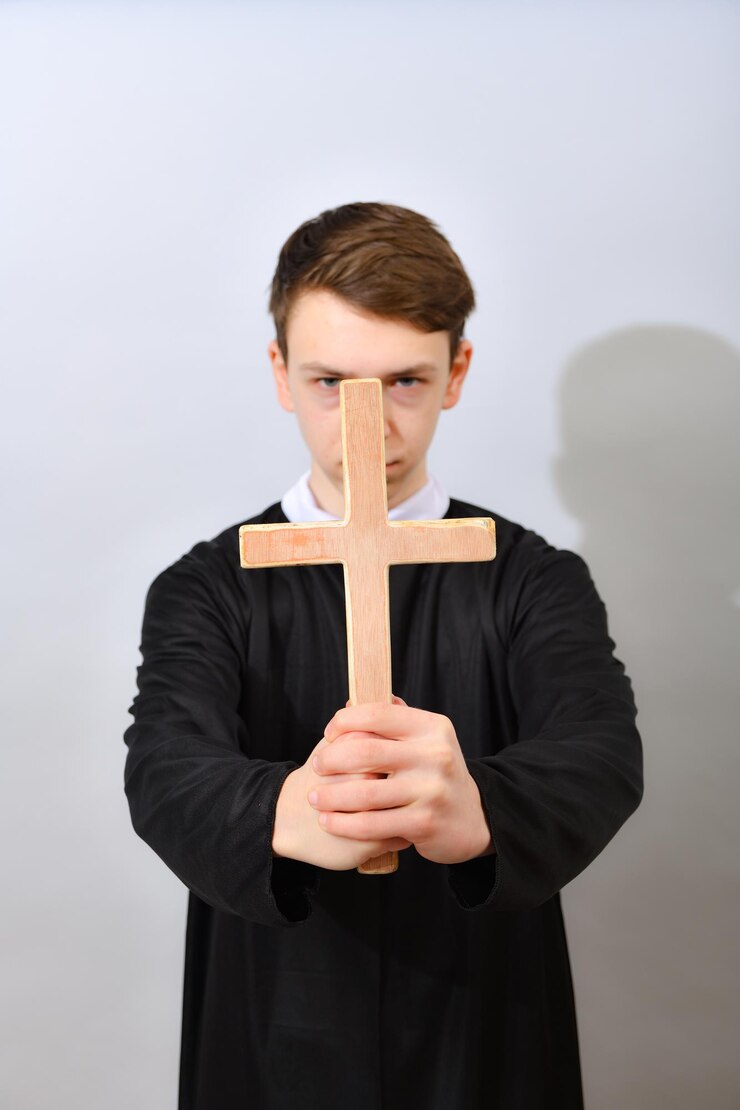 Foto um jovem padre católico segura uma cruz na frente dele o conceito de expulsar o diabo e os maus espíritos