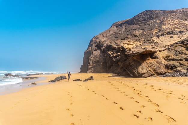 Um jovem pai no Roque del Moro da praia Cofete do parque natural de Jandia, Barlovento, ao sul de Fuerteventura, nas Ilhas Canárias. Espanha