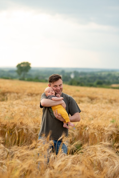 Um jovem pai segura seu filho de três meses nos braços.