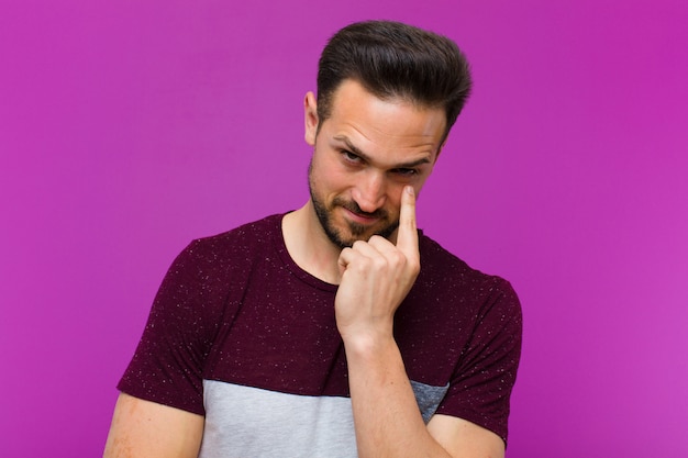 um jovem posando enquanto mostra que ele está de olho em você