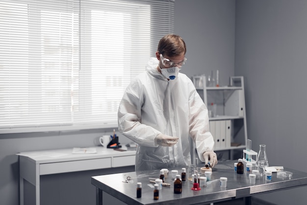 Um jovem químico, estudante fazendo experiências em um laboratório escolar.