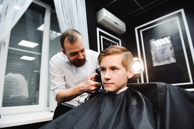 Um jovem rapaz bonito cortando o cabelo