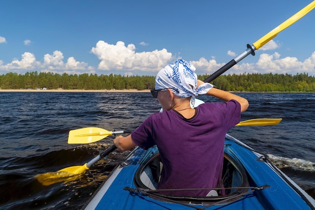 Um jovem rema um caiaque no Lago Ladoga