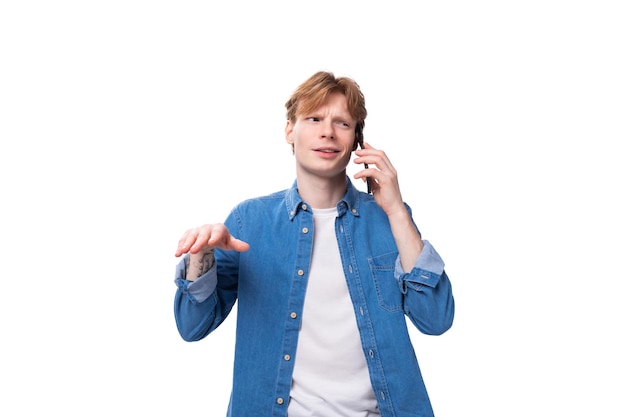Um jovem ruivo escuta com indignação o interlocutor ao telefone.
