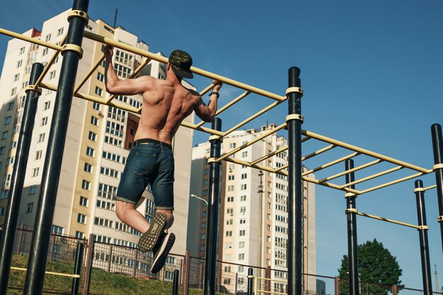 Um jovem se levanta no campo de esportes, um atleta, treinando ao ar livre na cidade