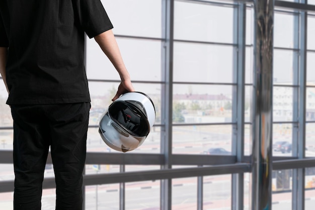 Um jovem segurando capacete de corrida branco para automobilismo