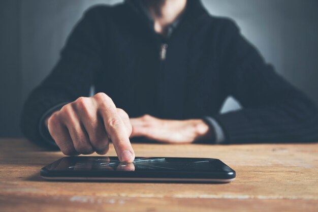 Um jovem segurando um smartphone quebrado