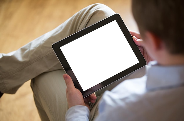 Um jovem sentado com um tablet na mão