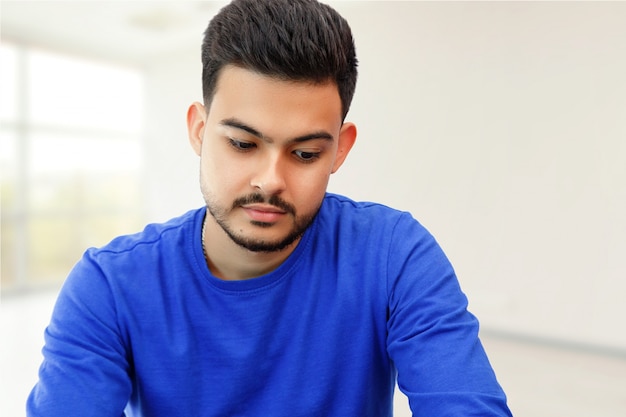 Um jovem sentado em um laptop em busca de trabalho, fazendo negócios na internet. na luz