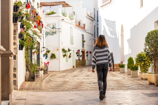 Um jovem turista andando pelas casas brancas da cidade de Nerja, Andaluzia. Espanha. Costa del sol no mar mediterrâneo