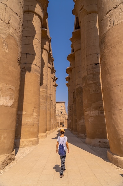 Um jovem turista de chapéu visitando o Templo Egípcio de Luxor