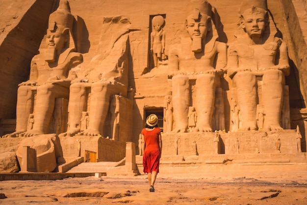 Um jovem turista em um vestido vermelho entrando no templo de abu simbel