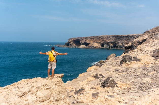 Um jovem turista na trilha em direção às cavernas de Ajuy, Pajara, na costa oeste da ilha de Fuerteventura, nas Ilhas Canárias. Espanha