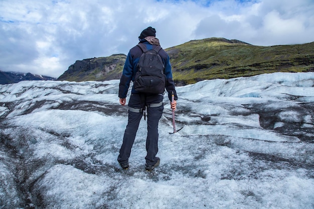 Um jovem turista no gelo da geleira Svinafellsjokull Islândia