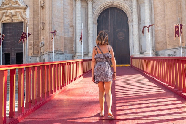 Um jovem turista no tapete vermelho da Catedral de Santa Iglesia na cidade de Cádiz Andaluzia