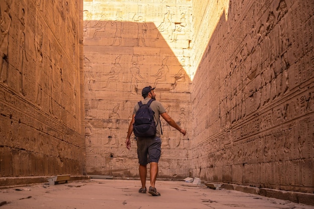 Um jovem turista visitando o belo templo de Edfu na cidade de Edfu Egito