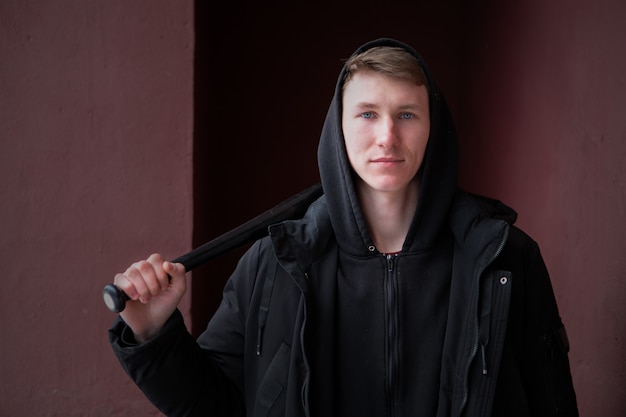 Um jovem valentão com um taco de beisebol pendurado no ombro