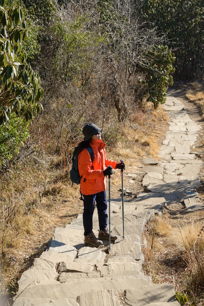 Um jovem viajante caminhando na trilha da floresta no Nepal