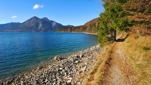 um lago com uma casa na costa e um lago no fundo