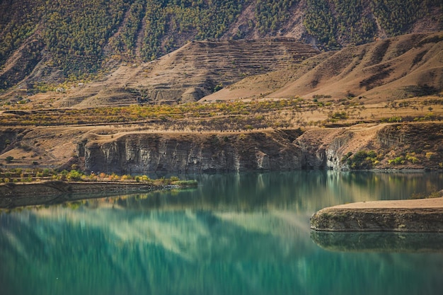 Foto um lago com uma montanha verde ao fundo