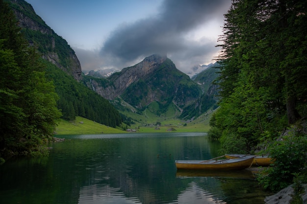 Um lago de montanha com barcos em uma bela montanha em tempo nublado