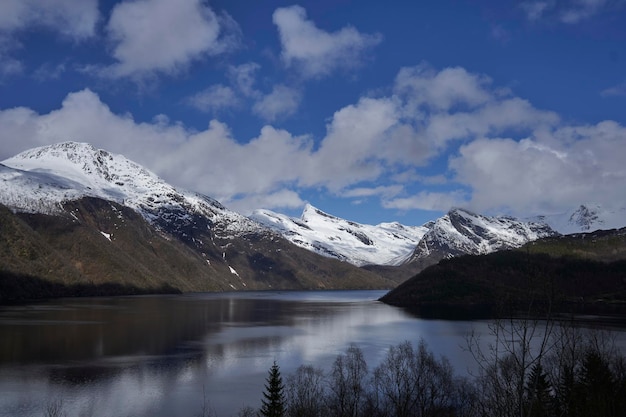 Um lago nas montanhas com neve nas montanhas