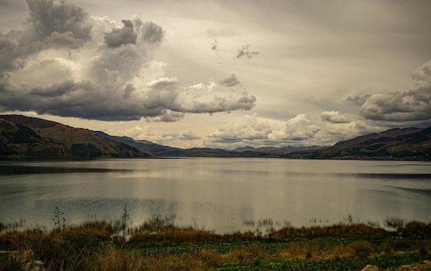 Um lago nas montanhas com um céu nublado