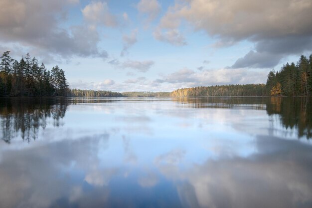 Um lago pitoresco e calmo da floresta Nuvens refletindo na água