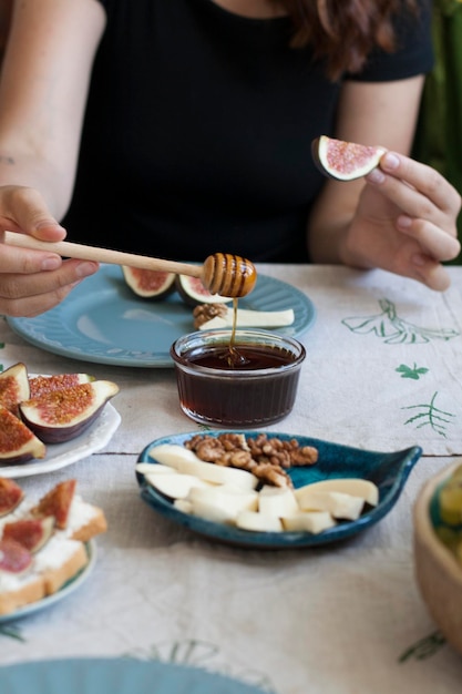 Um lanche saboroso uma tigela de pratos de mel de queijo sulguni com nozes fatias de figo e pão branco