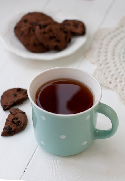 Foto um lanche saboroso: uma xícara de chá e um prato de biscoitos.