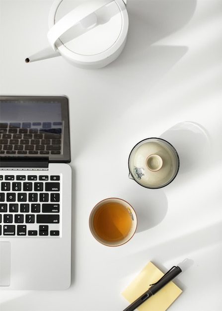 Um laptop com uma xícara de chá e um bule sobre ele Perfis de sabor do chá por técnica de preparo