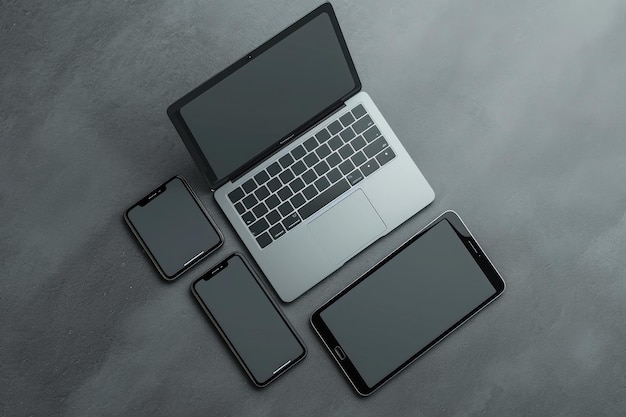 Um laptop e um tablet estão dispostos cuidadosamente em uma mesa em um espaço de trabalho moderno Smartphone laptop e tablet sincronizados em uma renderização mínima AI Gerado