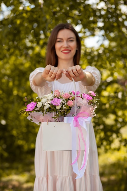 Um lindo buquê de flores em uma caixa nas mãos de uma garota