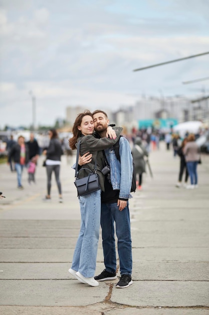 Um lindo casal apaixonado é fotografado tendo como pano de fundo uma exposição de carros antigos.