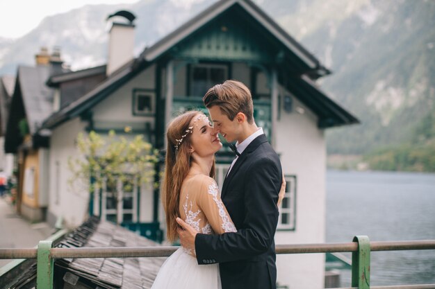 Um lindo casal de noivos anda na rua perto do lago em uma cidade fada austríaca