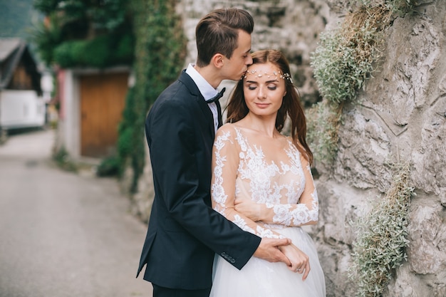 Um lindo casal de noivos caminha em uma cidade fada austríaca, Hallstatt.