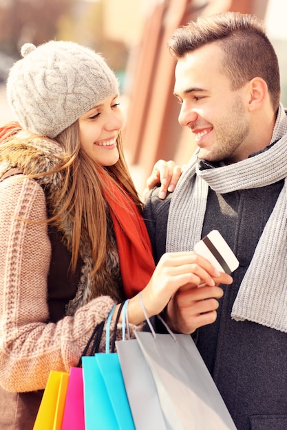 Um lindo casal fazendo compras com cartão de crédito na cidade