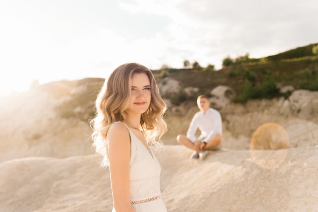 Um lindo casal jovem apaixonado por um homem e uma mulher abraçam o beijo perto de um lago azul e areia ao pôr do sol férias no mar na praia pôr do sol manhã lua de mel trópicos oceano relacionamento menina