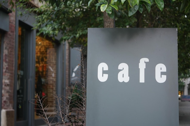 Um lindo e encantador sinal de café aninhado e cercado de vegetação