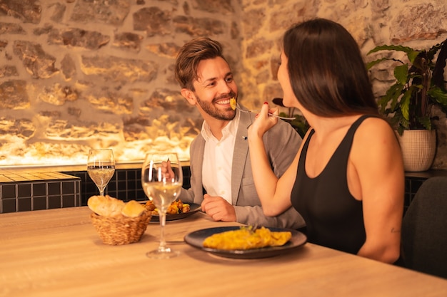 Um lindo jovem casal apaixonado em um restaurante, se divertindo jantando juntos