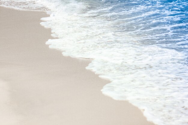 Um lindo mar e areia no fundo da viagem de férias na costa