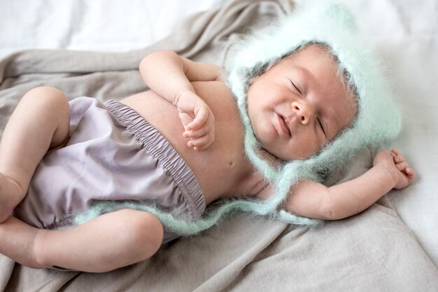 Um lindo menino recém-nascido dorme docemente em uma capa mole.