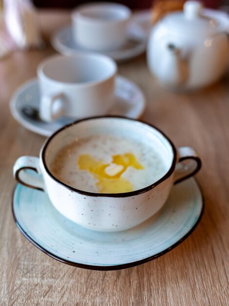 Um lindo prato branco com mingau de aveia e manteiga em cima da mesa