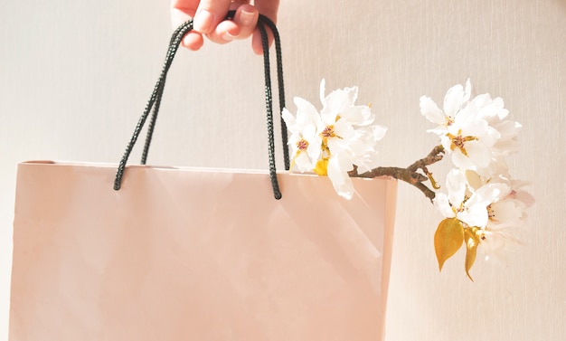 Um lindo ramo de flores da primavera em um saco de papel na mão de uma mulher. humor floral e romântico. um presente para uma mulher. celebração do dia da mulher.