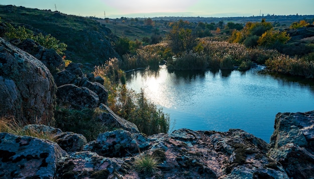 Um lindo riozinho reluzente entre grandes pedras brancas e vegetação verde nas colinas da Ucrânia