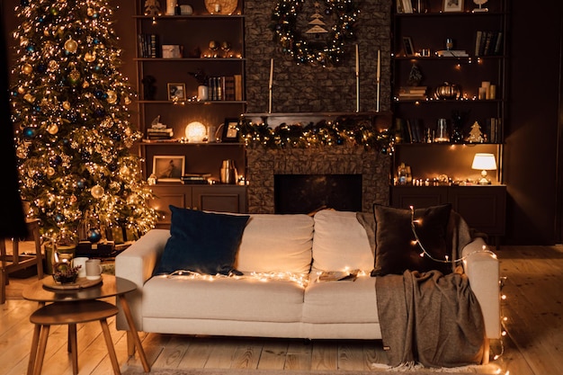 Um lindo sofá de luz suave com almofadas fica na sala de estar perto da árvore de Natal