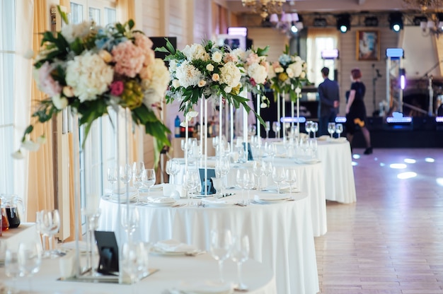 Um lindo vaso de flores sobre a mesa de um restaurante de luxo. Decorações de casamento.