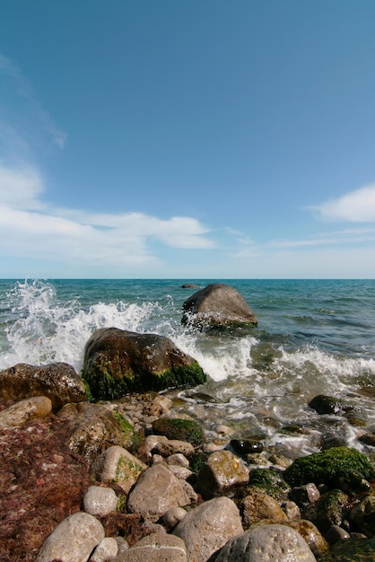 Um litoral rochoso com grandes pedras na água