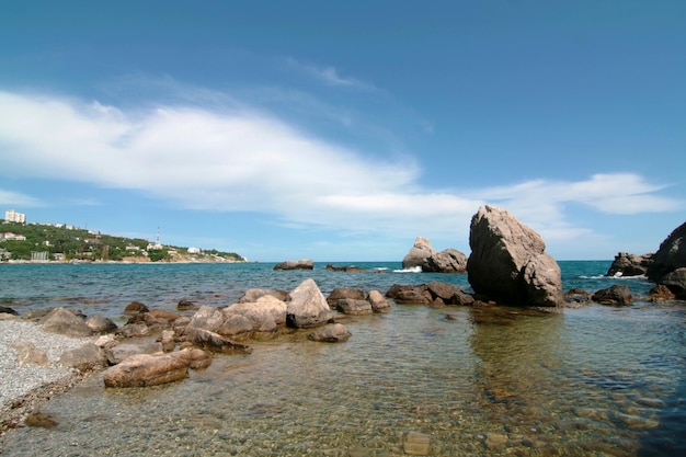 Um litoral rochoso com grandes pedras na água