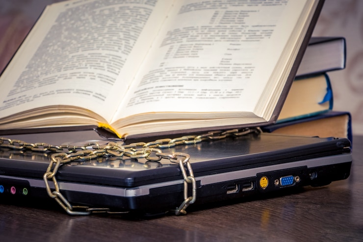 Foto um livro aberto está em um laptop ligado por uma corrente